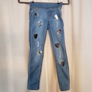 Distressed girl's jeggings with flip sequin hearts